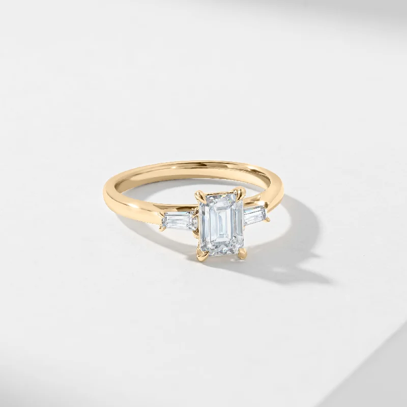 Princess - cut diamond engagement ring with a pavé - set band in platinum1.5ct Emerald Cut Diamond With Tapered Baguette Shoulders Trilogy Ring 1.62tdw